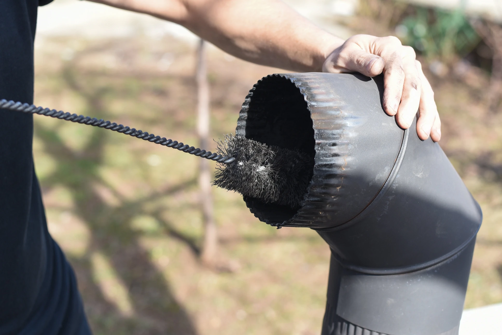 Extérieur, personne effectuant maintenance de conduit de cheminée, nettoyage avec brosse hérisson