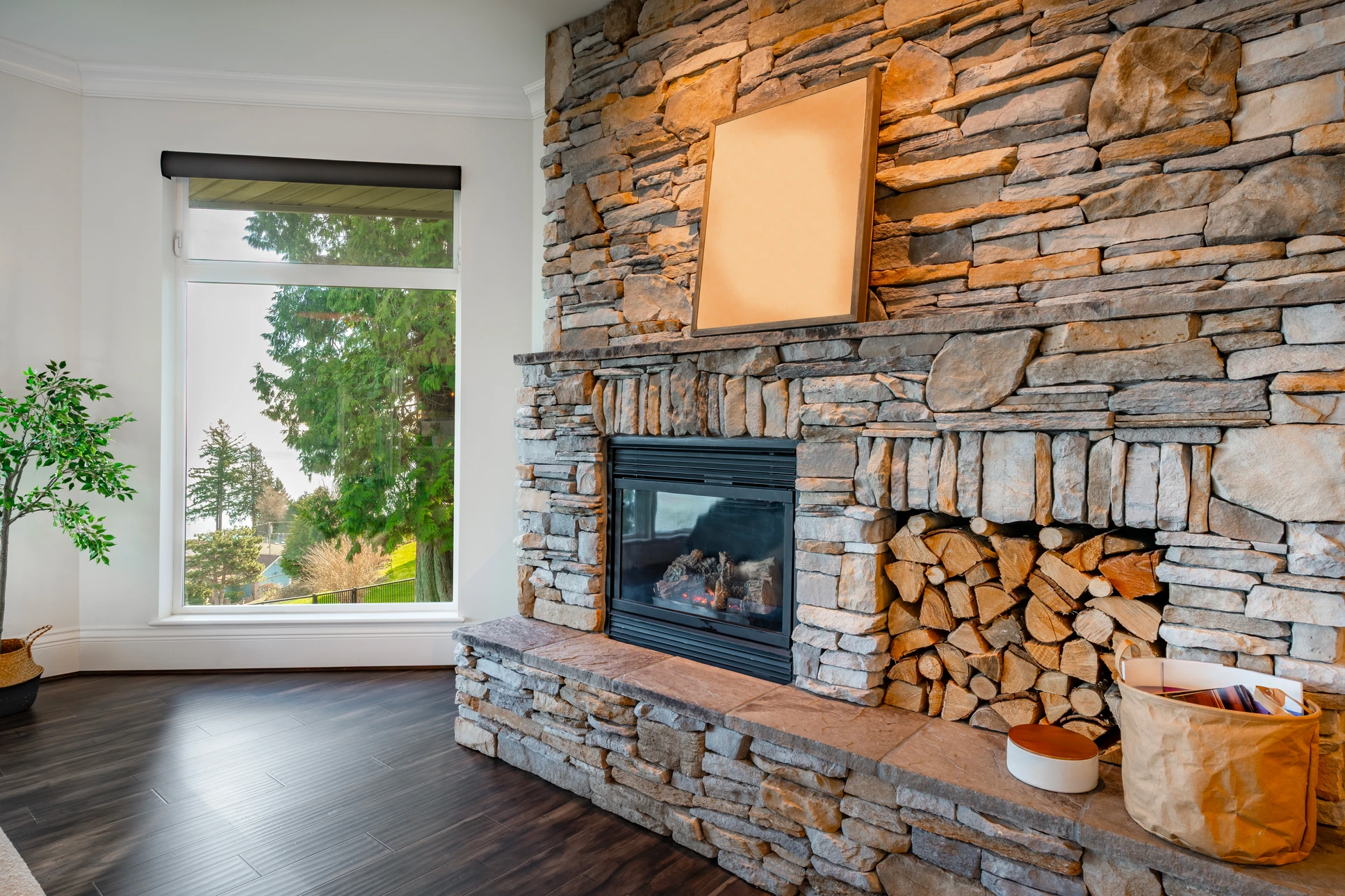 Intérieur rustique avec cheminée en pierres naturelles, feu allumé, manteau en bois massif brut